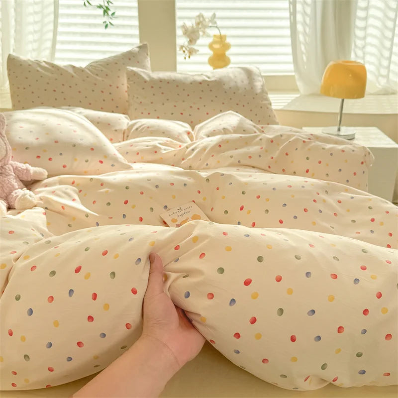 A beige duvet set with a cute dog print featuring small colorful dots, displayed on a bed.