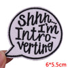 A black and white embroidered patch shaped like a speech bubble with the text Shhh I'm Introverting