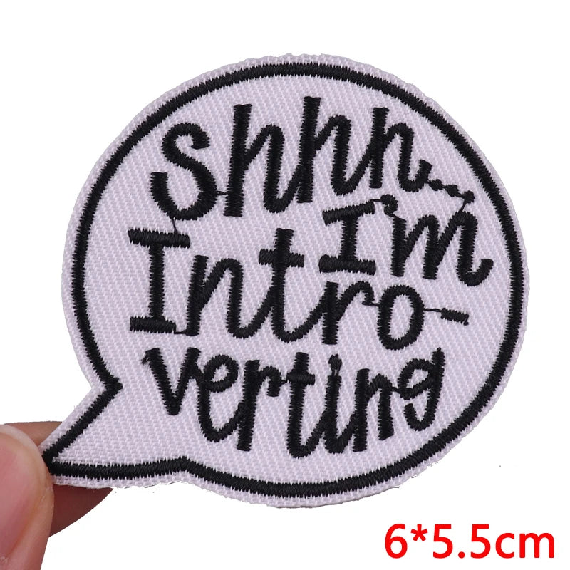 A black and white embroidered patch shaped like a speech bubble with the text Shhh I'm Introverting