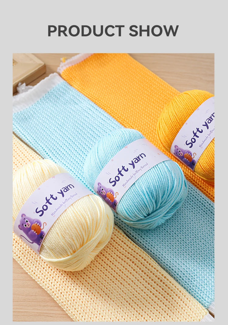 A close-up of various skeins of soft yellow, light blue, and orange acrylic yarn laid out on a wooden surface.