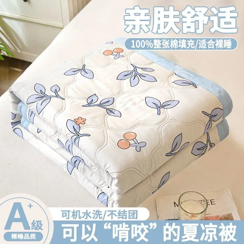 A stack of white quilted blankets with light blue floral patterns, suitable for dorms.