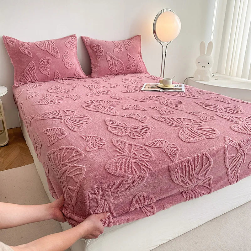 A pink jacquard weave fitted sheet bedding is shown on a bed with white linens and a rabbit figurine.