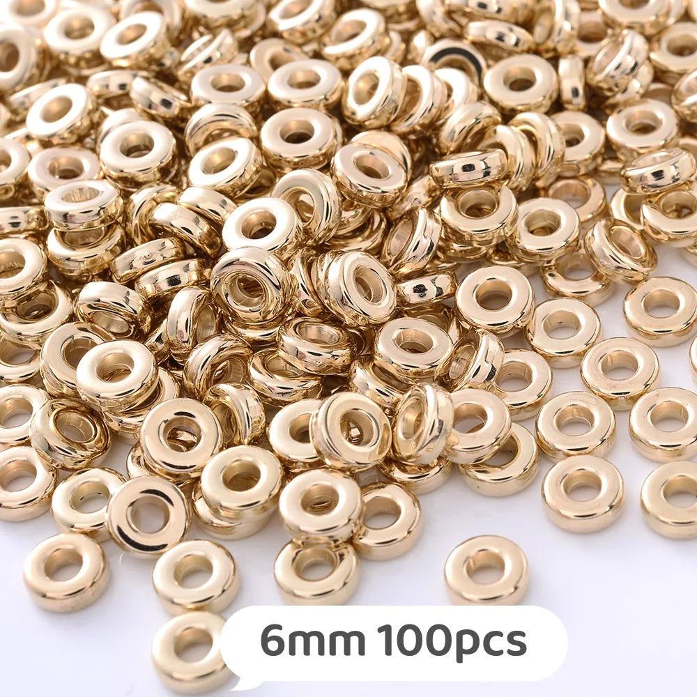 A pile of gold-colored geometric acrylic beads, 6mm size, for jewelry making.