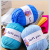 A collection of soft yarn in blue and teal colors is displayed on a wooden surface.
