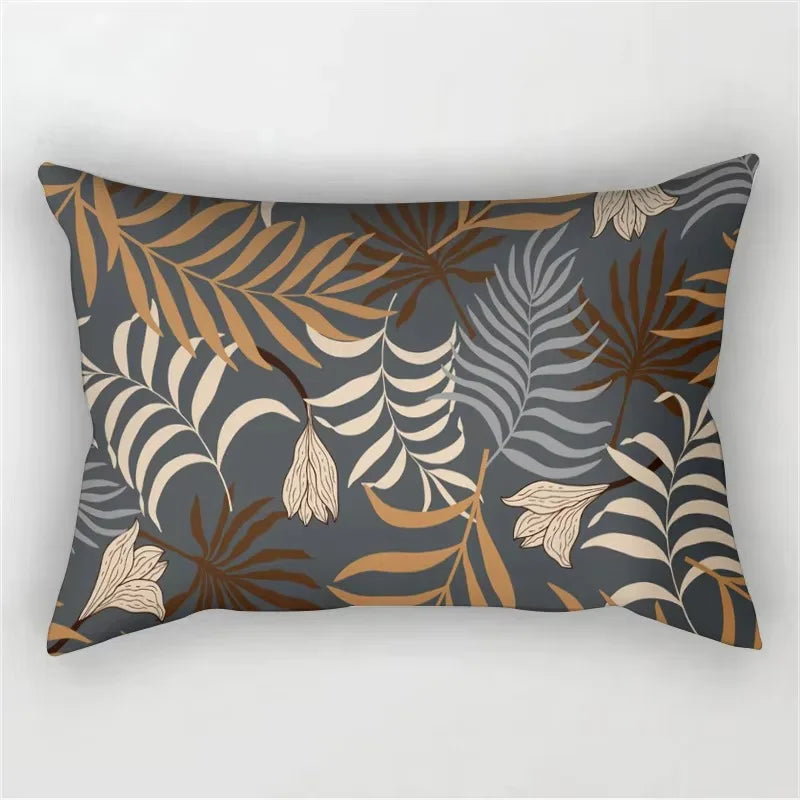 A decorative pillowcase featuring a tropical leaf print in shades of brown, beige, and gray on a dark blue background.