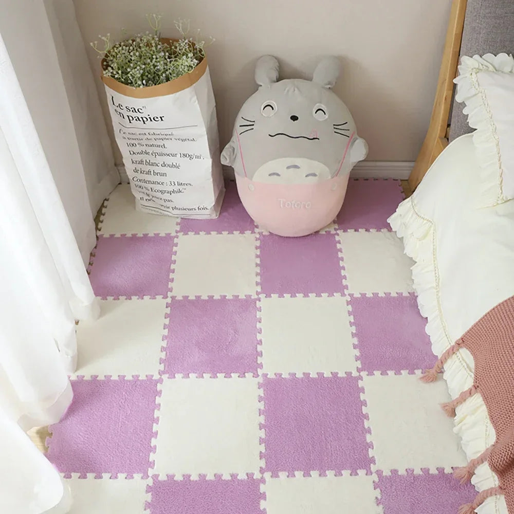 A soft plush white mat with purple tiles and a gray animal toy sitting on a light-colored floor.