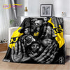 A black and yellow flannel throw blanket featuring a collage of faces with hands reaching out.