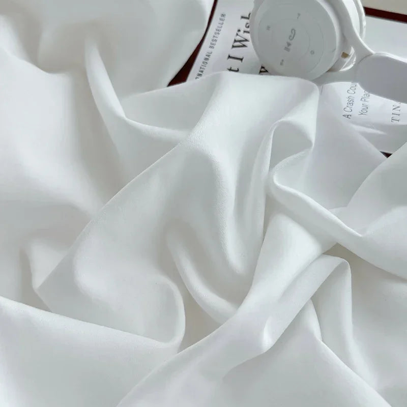 White adjustable fitted bed sheet cover draped next to a white circular item.