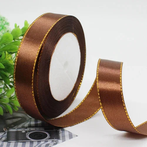 Roll of brown satin ribbon with gold edge for gift wrapping and crafts