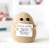 A handmade beige plush pocket doll with a sign that reads Positive potato