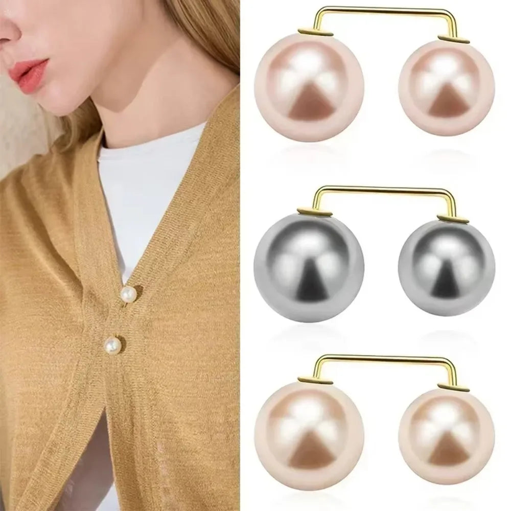 A set of gold-toned pearl drop earrings and a matching pearl brooch displayed against a neutral background.
