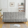 A gray velvet non-slip armless sofa cover displayed on a wooden floor with an oriental rug.
