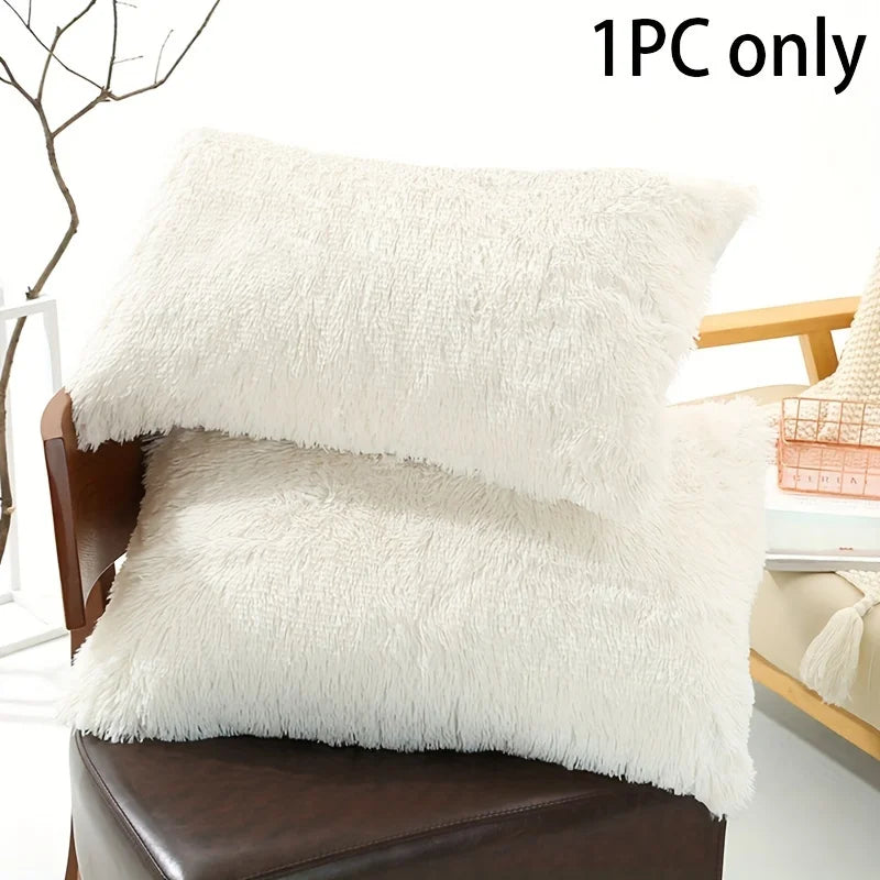 One piece of white faux fur pillow covers resting on a brown leather chair.