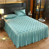 Light blue quilted bed skirt with a tufted headboard and bedding in a bedroom setting