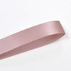 A roll of pink double-sided satin craft ribbon shown in profile.