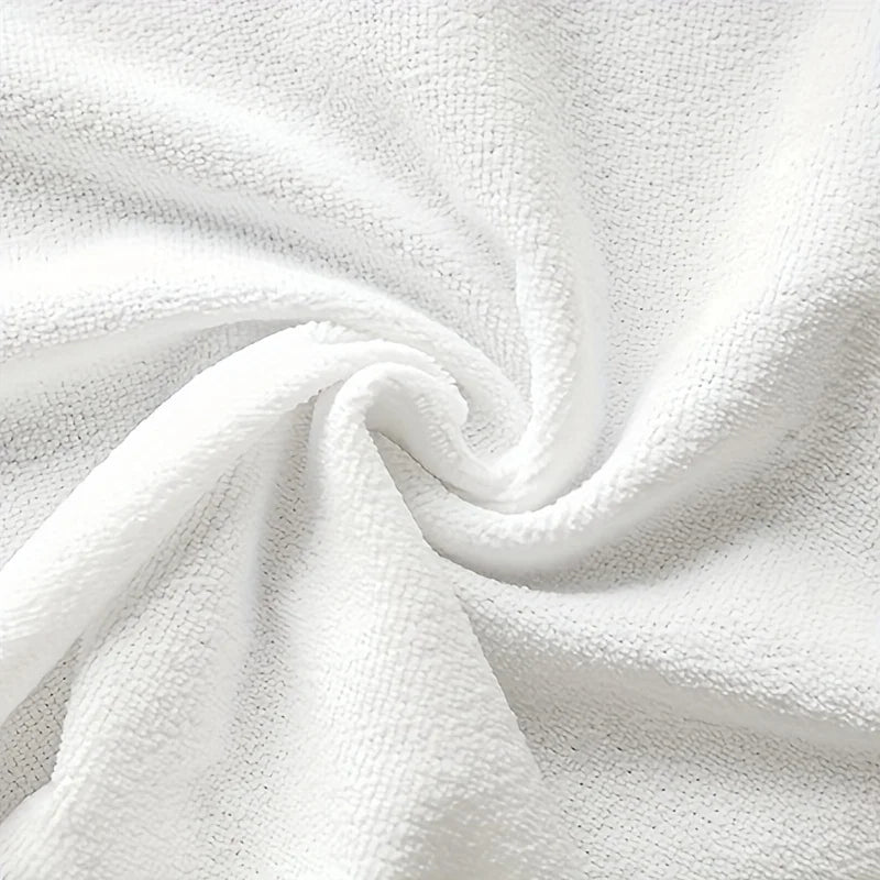 A close-up view of a white absorbent kitchen towel fabric, tightly rolled and draped.