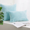 A light blue corduroy striped throw pillow cover resting on a white surface.