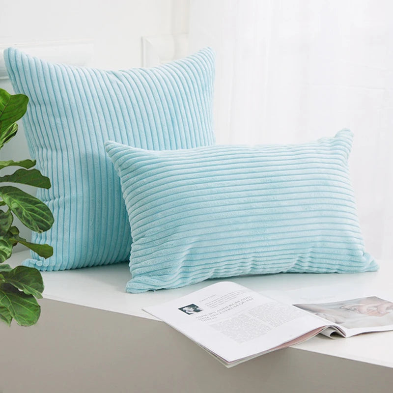 A light blue corduroy striped throw pillow cover resting on a white surface.