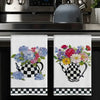 A set of two black and white checkered kitchen towels featuring floral designs.