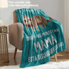 A teal knit throw blanket featuring a graphic of a sloth and text that reads Mama está descansando los ojos