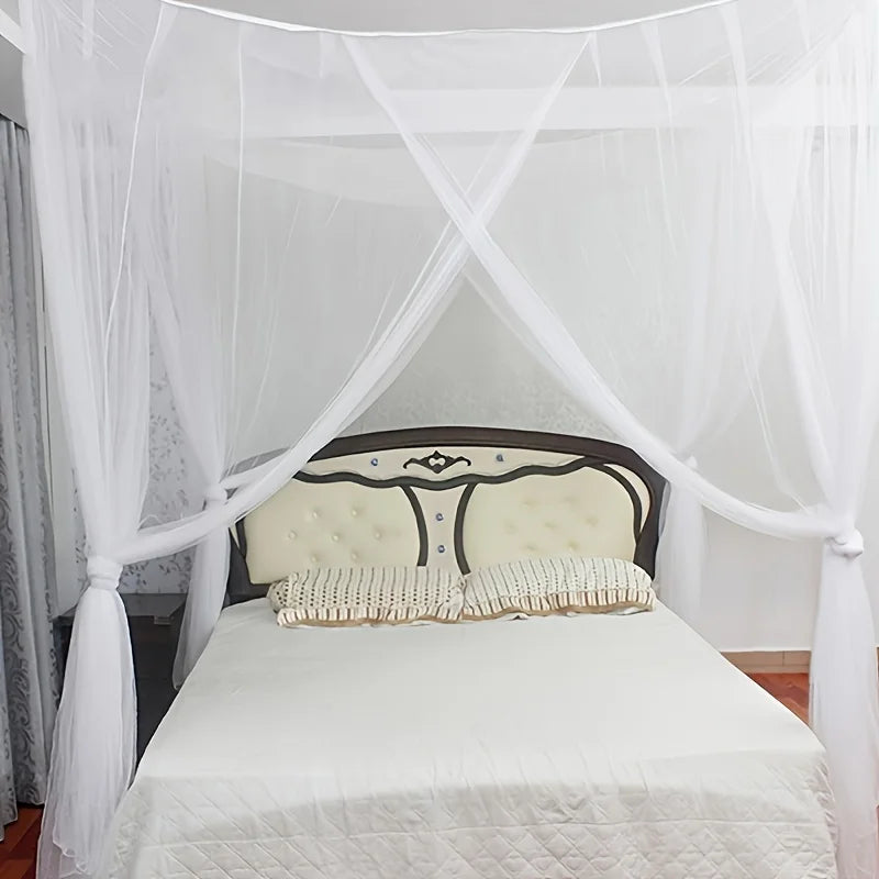 White sheer mosquito net curtains draped over a bed frame