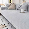A light gray chenille sofa protector cover with black stripes and a white candle on the surface.