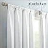 White floral print curtains hanging from a rod, showing the fabric and hardware.