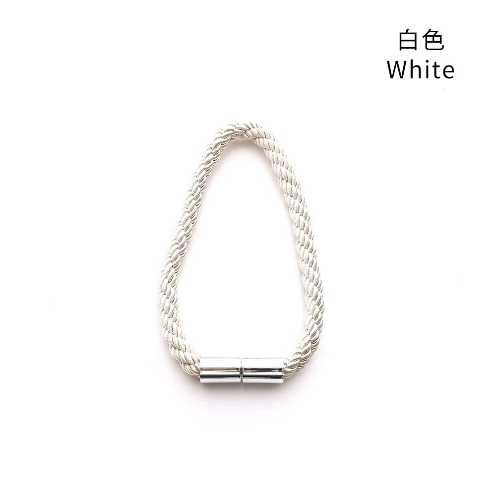 A white magnetic curtain tieback clip with a braided cord texture.