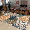 A large outdoor area rug featuring a tropical botanical pattern in shades of orange, teal, and blue on a light floor.