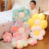 A collection of soft, pastel-colored sunflower plush flowers arranged on a wooden floor.