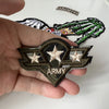 A hand holds a military style embroidered patch featuring a star and the word ARMY on a dark green background.