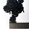 A cluster of black embroidered rose flower patches shown next to a ruler for scale.