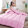 A fluffy pink quilted comforter or duvet displayed on a bed.
