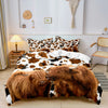 Highland cow print bedding set featuring brown and white patterns displayed on a bed.
