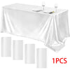 A white rectangle satin tablecloth set with silverware and wine glasses displayed on a table.