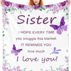 A woman holds a white blanket featuring purple floral designs and the text Sister I hope every time you snuggle this blanket 