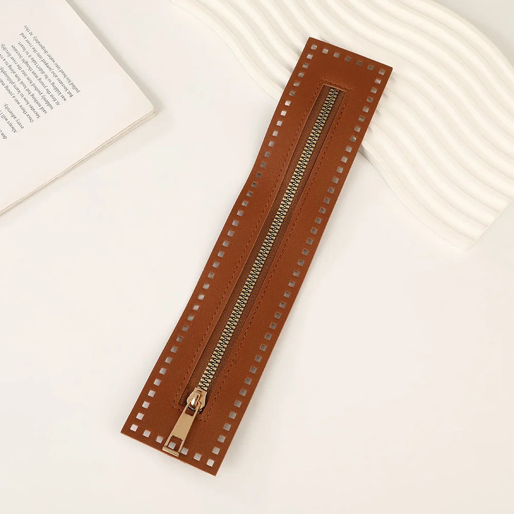 A brown PU leather zipper frame with studs is shown on a white surface.