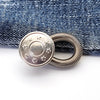 Silver extender buttons attached to a dark blue denim fabric.