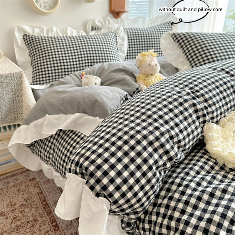 A plaid duvet cover set featuring black and white gingham fabric with white lace embroidery and fluffy yellow accents.