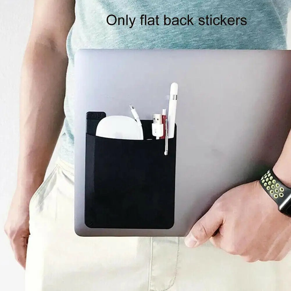 A person holds a laptop with a black storage pouch attached to the back, showing only flat stickers inside.