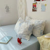 A set of three light blue floral duvet covers and pillowcases displayed on a bed.