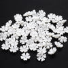 A pile of small white imitation pearl flower spacer beads for DIY jewelry