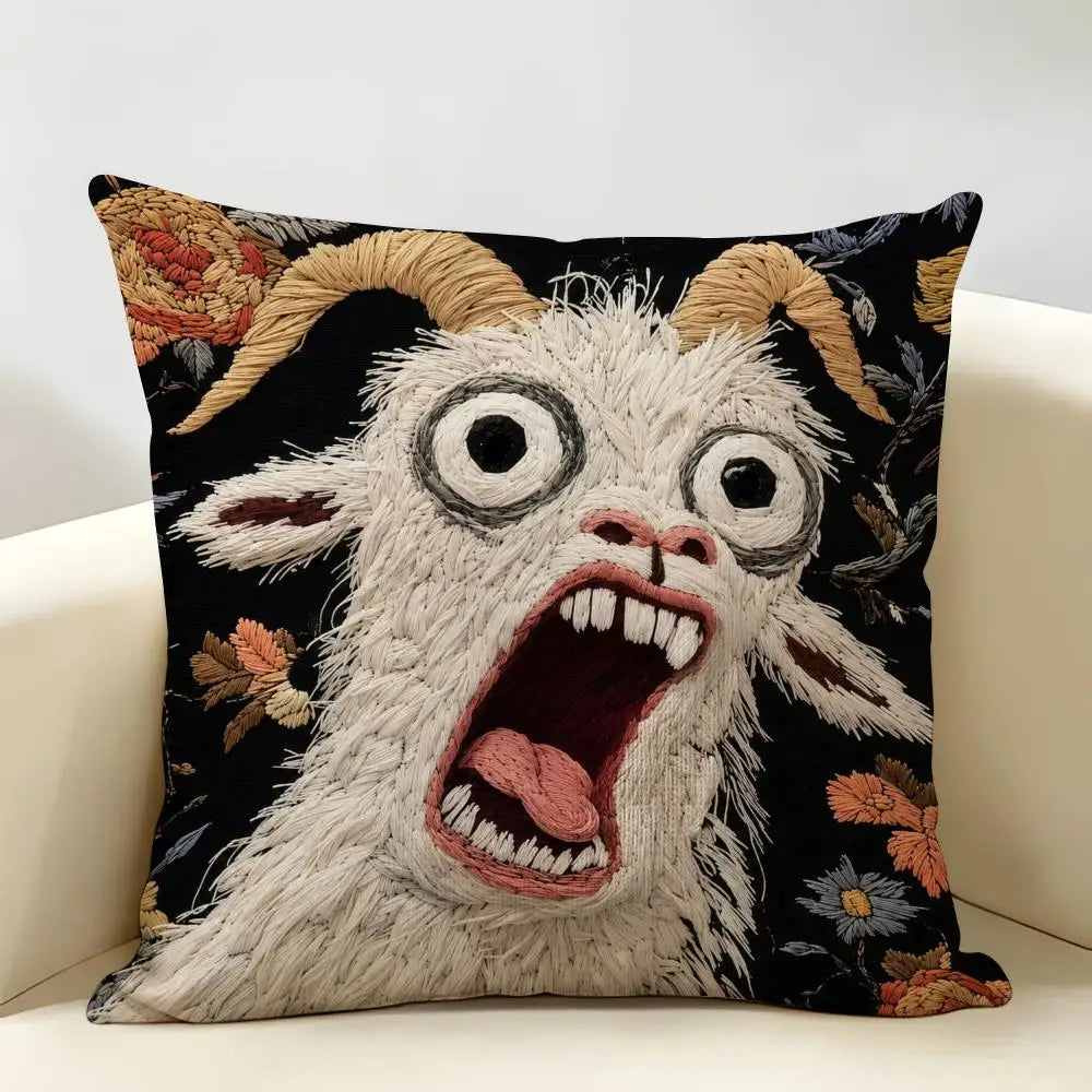 A fluffy white goat face with wide eyes and an open mouth is featured on a black cushion cover.
