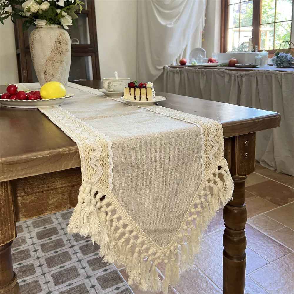 A beige crochet macrame lace table runner draped over a wooden table.