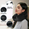 A woman is using a black, adjustable travel neck pillow with a sturdy buckle and zipper design.