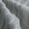 Close-up of a textured gray cotton face towel fabric folded and draped.
