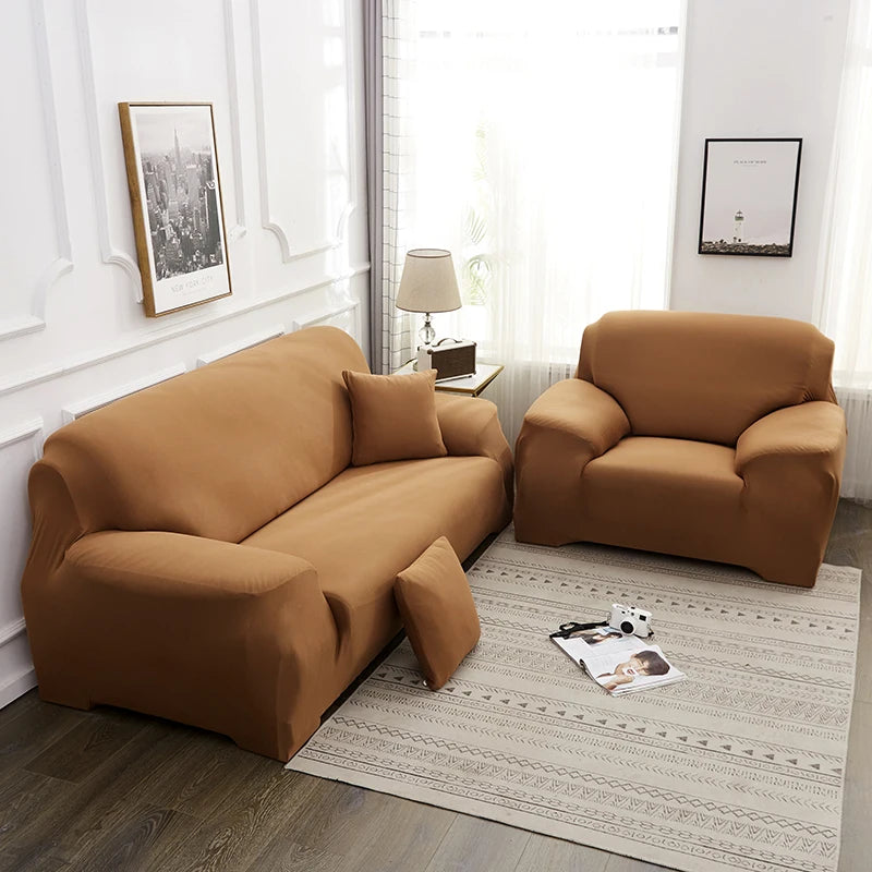 A tan faux silk sofa cover is displayed on a light rug in a bright room with a window and framed art.