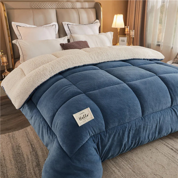 A deep blue weighted fleece blanket is displayed on a bed, featuring a beige sherpa trim and quilted texture.