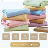 A stack of soft, breathable bamboo fiber cooling blankets in various pastel colors like mint green, light blue, pink, and bei
