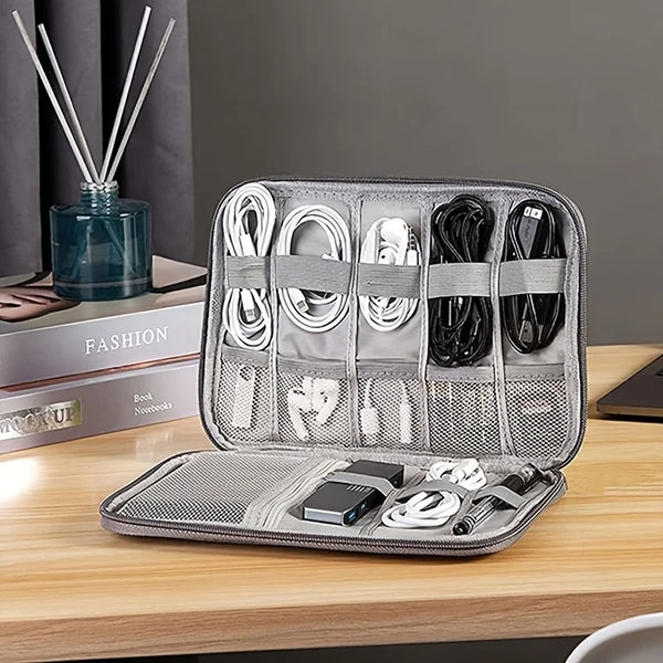 A silver portable multi-pocket cable organizer case with multiple slots for storing charging cables and wires.